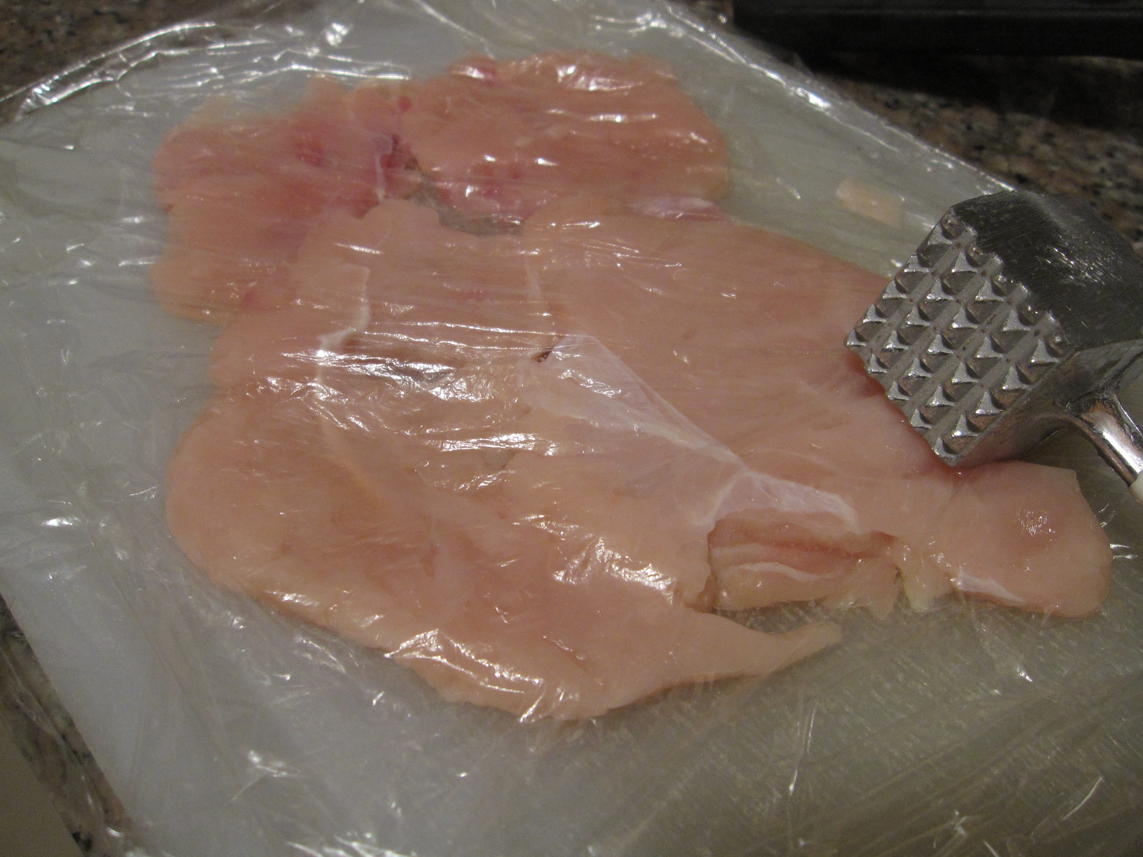 Pound chicken in plastic wrap